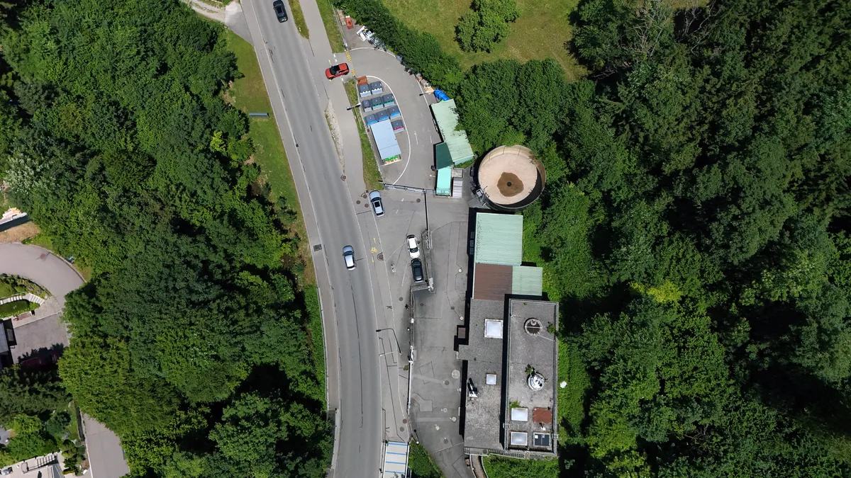 Die Wertstoffsammelstelle aus der Vogelperspektive: Vom Gasometer bis an den unteren Rand des Bilds ist die ehemalige Ara-Anlage zu sehen, die rückgebaut und renaturiert werden muss. Man sieht die Wertstoffsammelstelle in Weisslingen aus der Vogelperspektive.